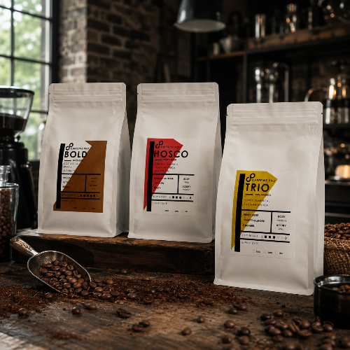 Three coffee bags with labels on a wooden surface with coffee beans.